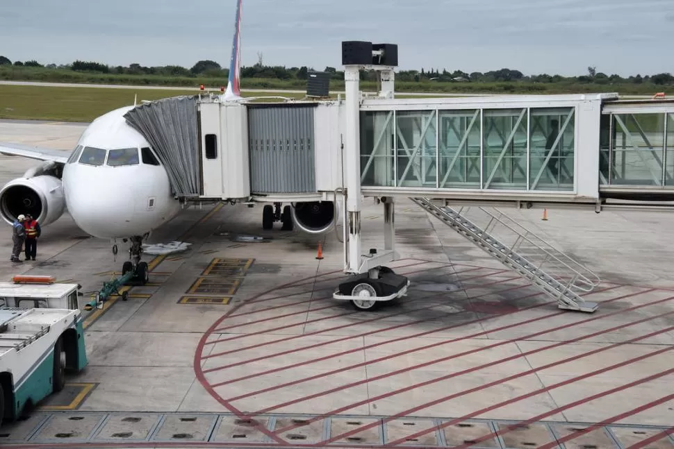 EN TUCUMÁN. El avión de Latam, en la manga del Benjamín Matienzo. LA GACETA / FOTO DE JOSÉ NUNO.-