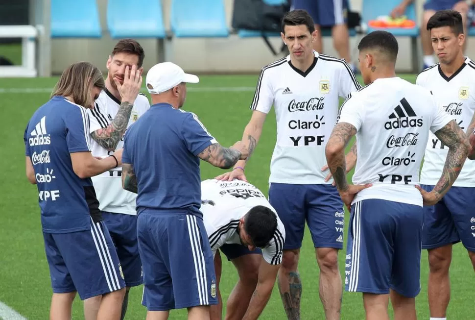 SOLOS Y ACOMPAÑADOS. A la izquierda, Meza cabecea sin marca alguna. A la derecha, Di María, Messi y el resto, escuchan a Sampaoli. fotos reuters 