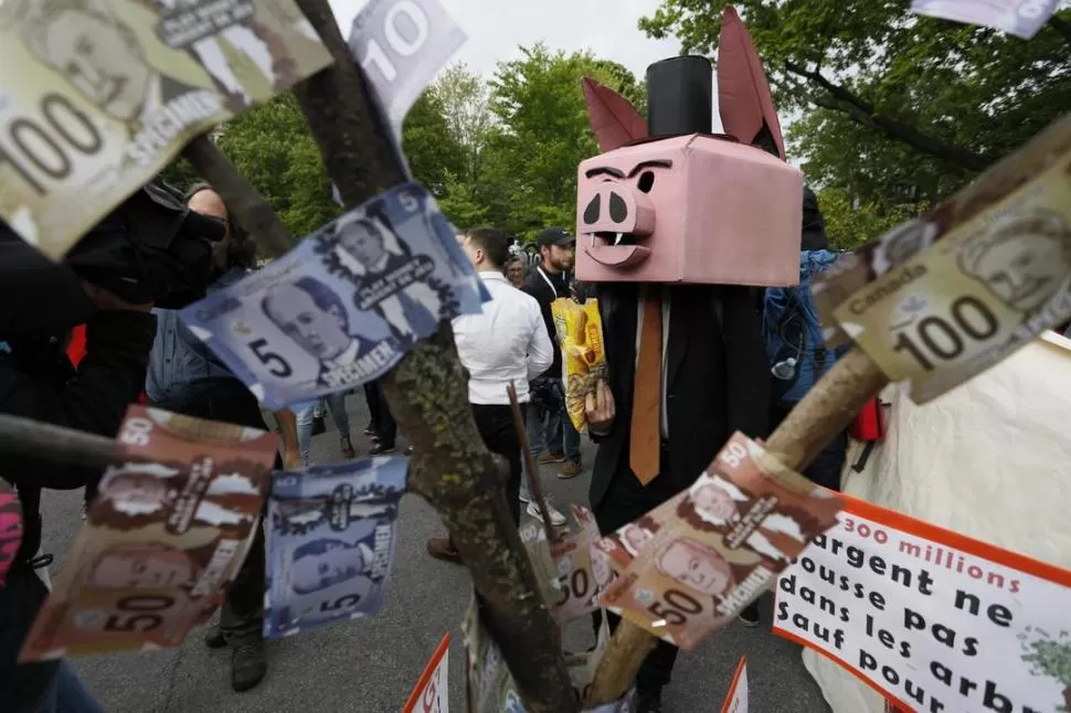 CABEZONES. Activistas de Oxfam protestaron con caretas con la imagen de Merkel, Trump y Macron.  Reuters