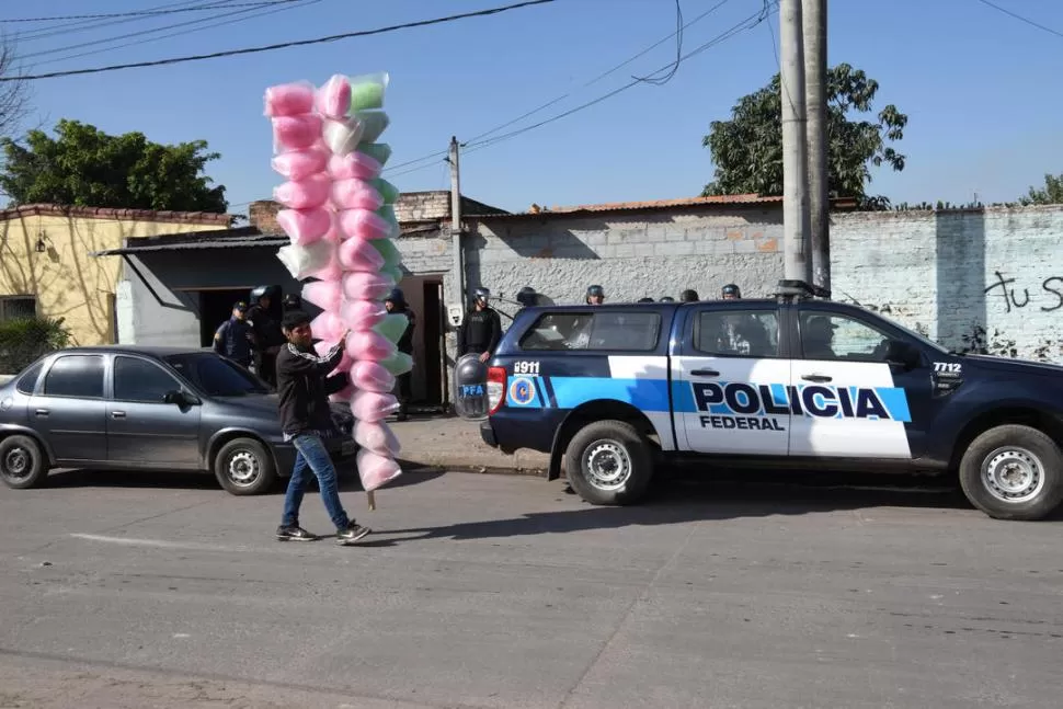 CONTRASTE. Un vendedor de algodón de azúcar pasa cerca de los federales. la gaceta / foto de jose nuno