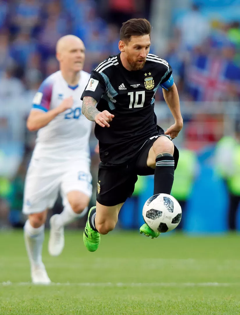 EN EL AIRE. A toda velocidad, Messi lleva la pelota hacia el arco islandés. reuters