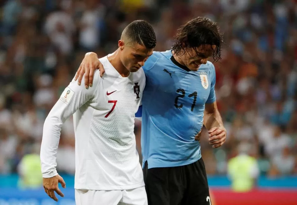 ENTRE ALGODONES. Cavani, con molestias en el gemelo derecho, se retira ayudado por Ronaldo. Es la duda para el viernes. reuters