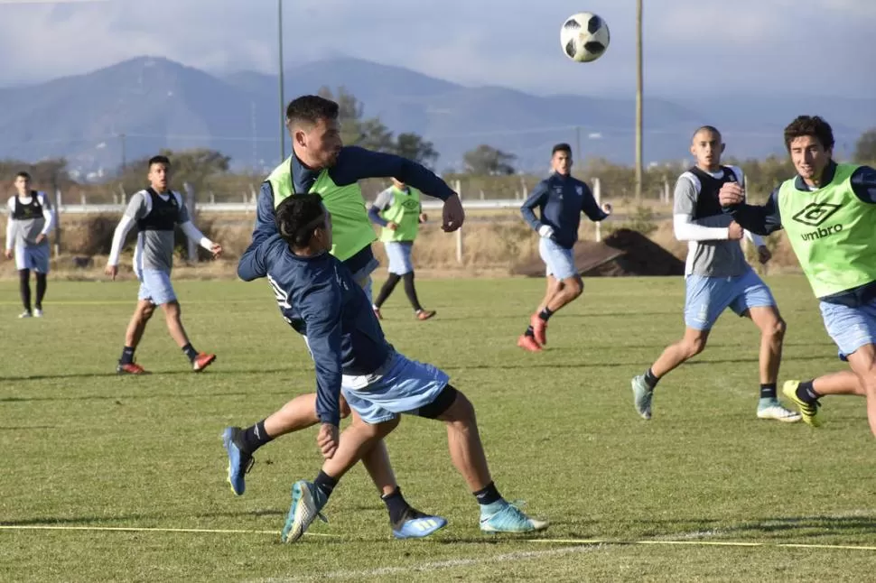 AGUERRIDO. Pese a que le sujetan la pechera, Abero continúa su marcha con la pelota durante el entrenamiento de Atlético en la cancha del Hotel de la Liga, en Salta. El lateral espera ansioso los clásicos.  la gaceta salta / foto de Marcelo MilleR