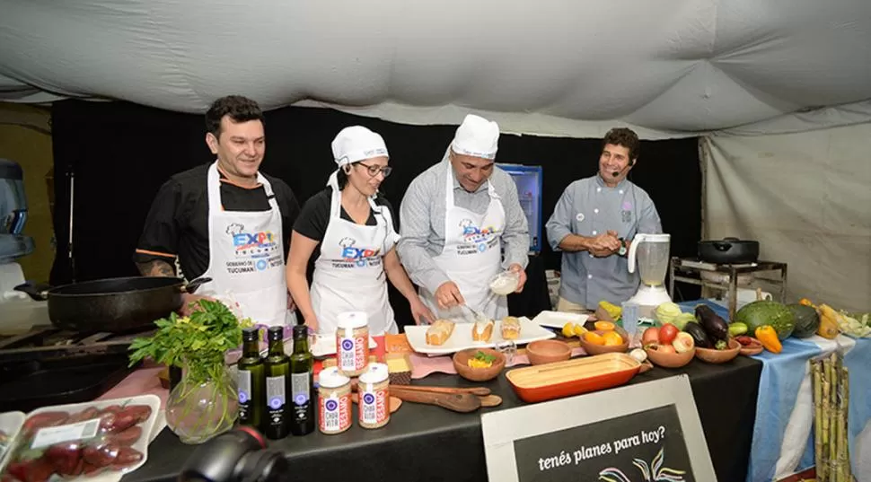 DEGUSTACIÓN. El gobernador Manzur comparte la elaboración de un plato con cocineros tucumanos en un stand. comunicación pública