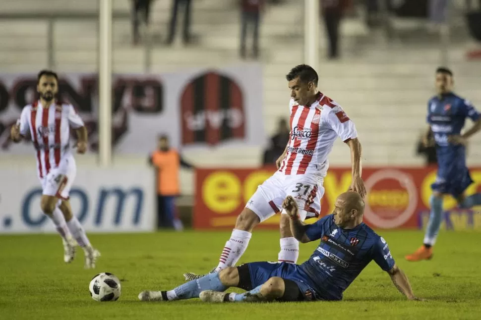 CON TODO. Renzo Vera se arrastra en el piso para sacarle la pelota a Nicolás Giménez. El volante “santo” mostró buen manejo, pero le faltó mayor dinámica. fotos matias gabriel napoli escalero ( especial para la gaceta)