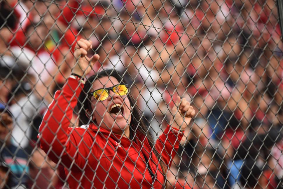 DE CARA AL SOL. Una fanática “santa” grita su felicidad tomada del alambrado.