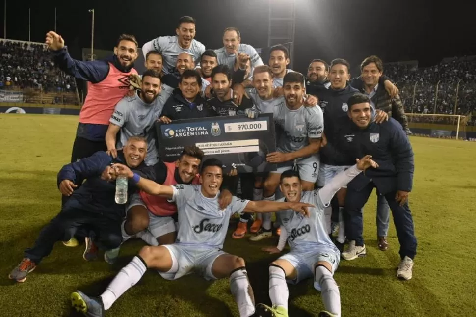 LA FELICIDAD ES SÓLO “DECANA”. Los jugadores de Atlético posan con el cheque que recibirá el club por la clasificación a octavos, donde todavía espera rival.  la gaceta salta / fotos de marcelo miller