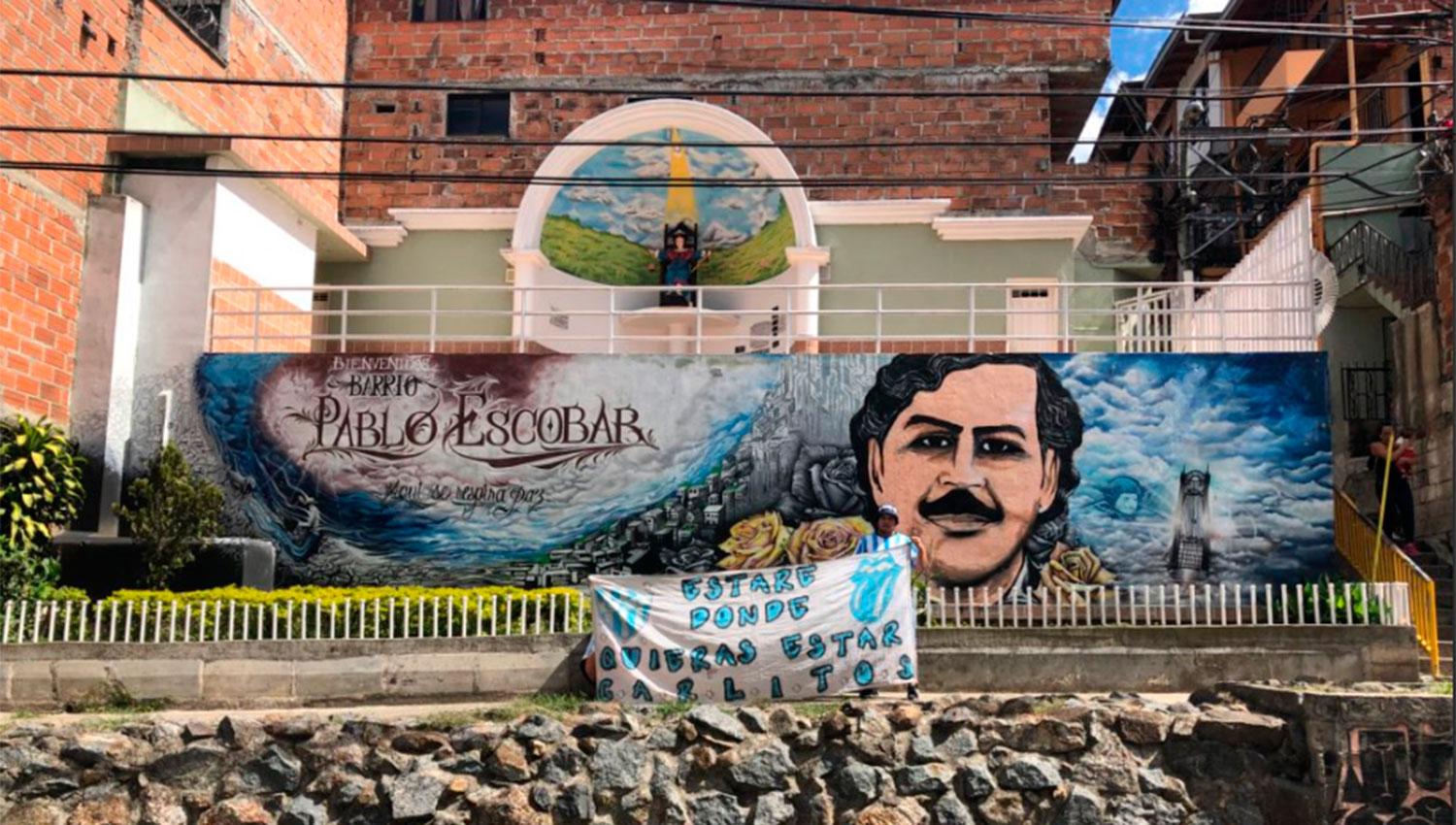 Carlos Amaya posó con su bandera en el mural que le hicieron a Pablo Escobar.