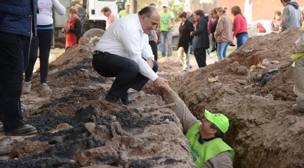 EN TAREAS. Manzur saluda a un operario, en una visita por barrio Villarroel. 