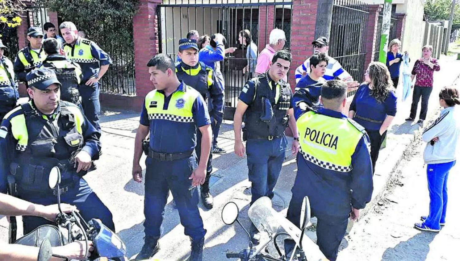 Policías y vecinos se arremolinaron frente a la casa de la víctima luego del incidente.