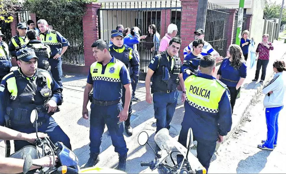 TENSIÓN. Policías y vecinos en la puerta de la casa de la víctima.  