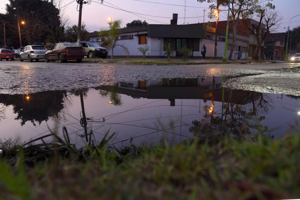 UN ESPEJO PUTREFACTO. Los derrames cubren veredas, cunetas y calzadas en Ejército del Norte al 2.000. Lo evidencia el charco en primer plano y también el taxi de fondo, que salpica mientras transita por la avenida.  