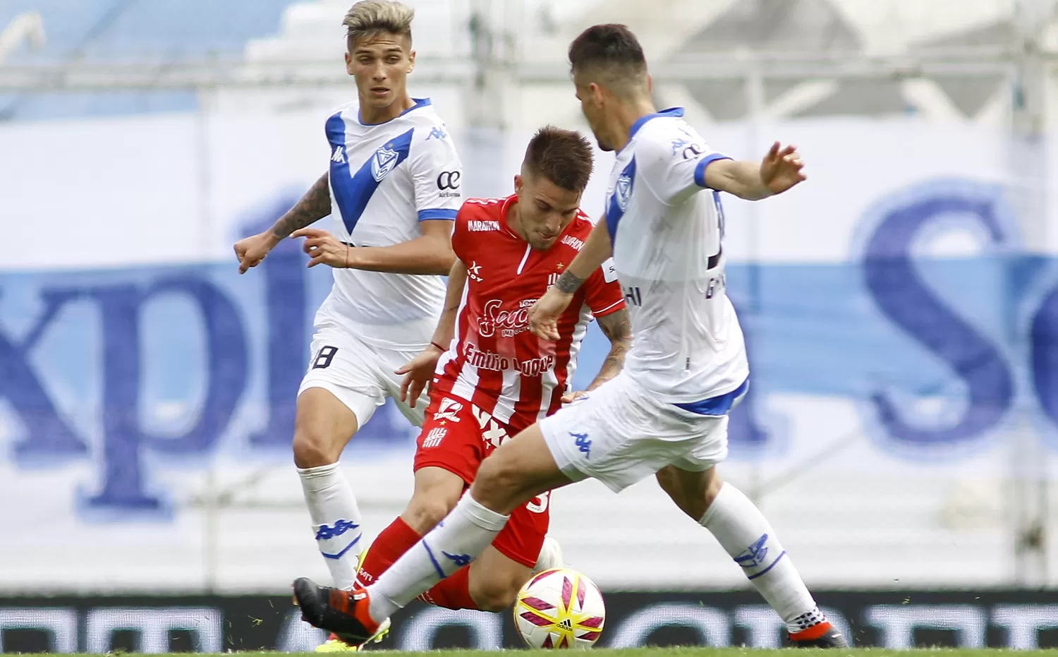 LO SUPERARON EN TODO. Purita maniobra entre dos rivales, en una imagen que fue una constante del juego. San Martín perdió todas las divididas y Vélez pareció coparle cada sector del campo de juego.