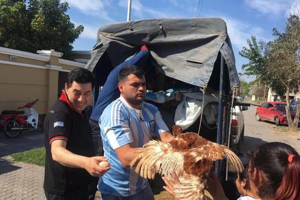 CON HUEVO Y TODO. Espeche repartió en persona las gallinas a sus vecinos.