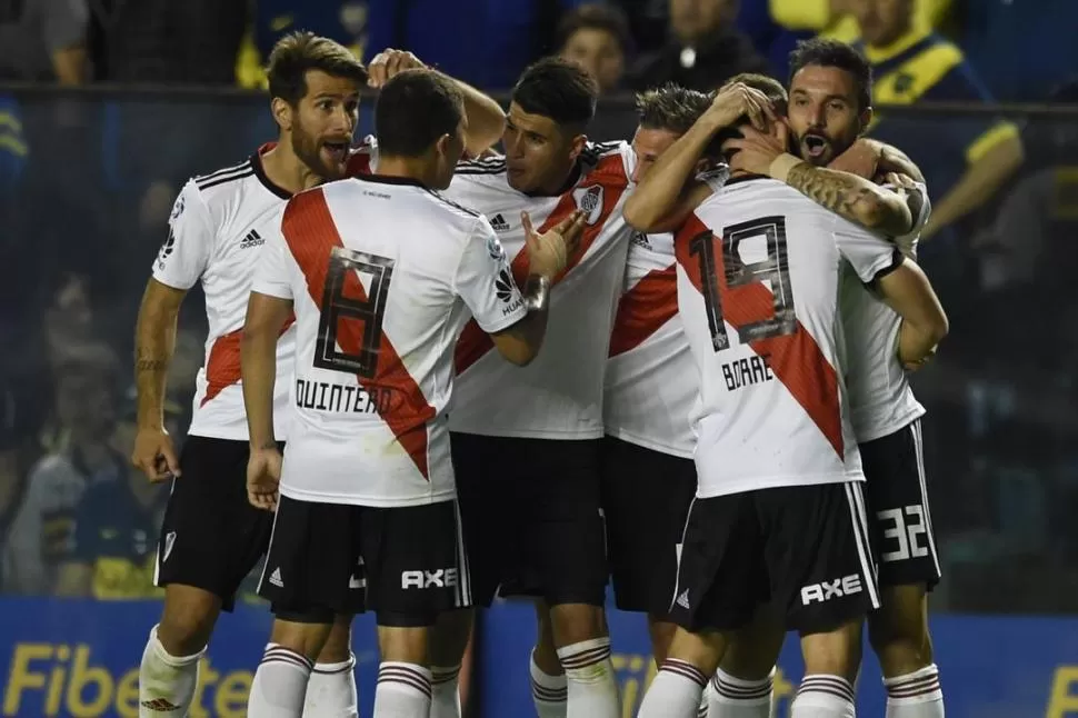 SENSACIÓN INDESCRIPTIBLE. Ponzio, Quintero, Palacios y Borré, entre otros, abrazan a Scocco autor del segundo gol. Los jugadores celebraron mientras en “La Bombonera” había un silencio sepulcral. PRENSA RIVER