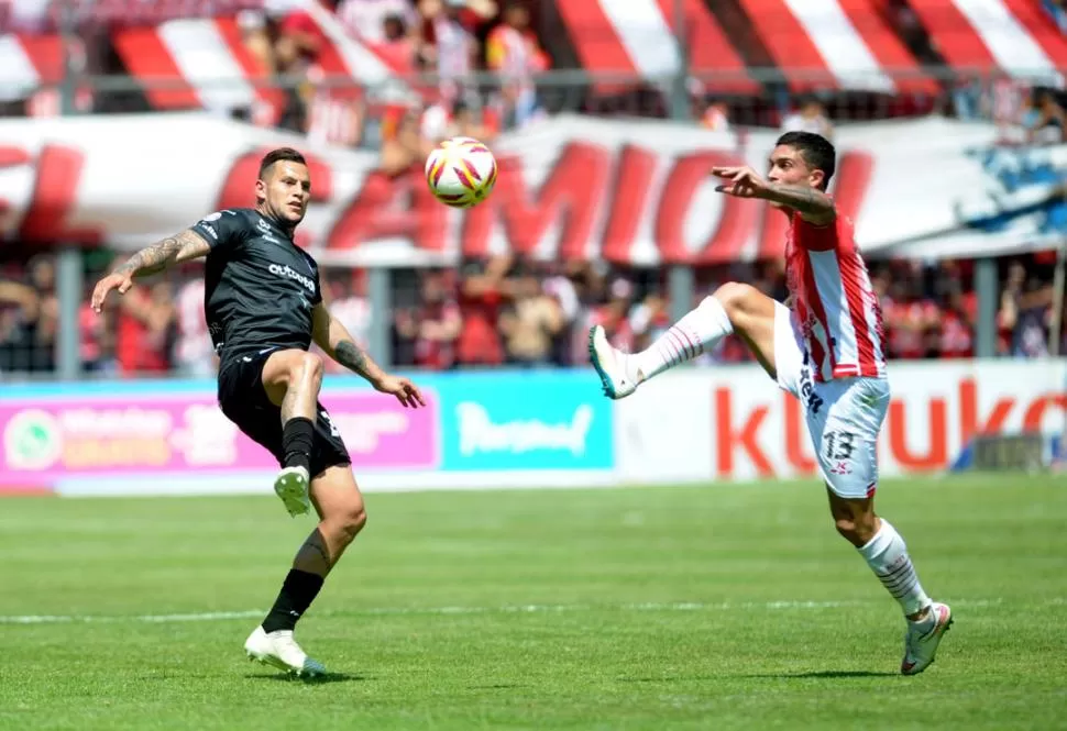 MEJORÓ, PERO NO FUE SUFICIENTE. Adrián Arregui no se guarda nada a la hora de disputar el balón, como sucede en esta acción contra Raúl Bobadilla. San Martín sigue sin ganar en la Superliga. la gaceta / foto de franco vera