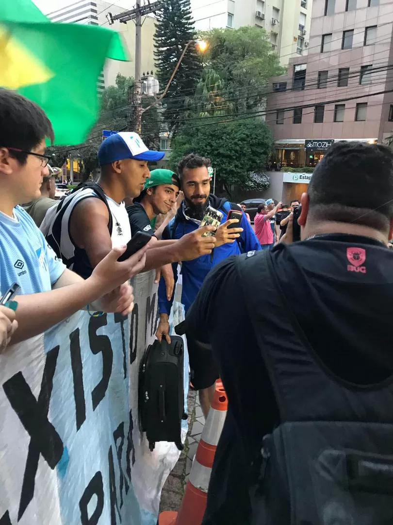 FOTOS PARA TODOS. El arquero suplente Alejandro Sánchez detiene su marcha camino al hotel para sacarse una foto con varios de los hinchas que fueron a esperarlos allí. Los jugadores fueron gentiles.   la gaceta / foto de leo noli