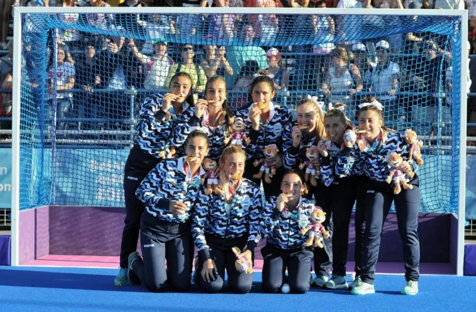 MUERDEN SUS MEDALLAS. Las “Leoncitas” posaron en uno de los arcos luego de la premiación y repitieron el ritual de cada deportista que gana una presea en los Juegos Olímpicos: morder el trofeo. TELAM