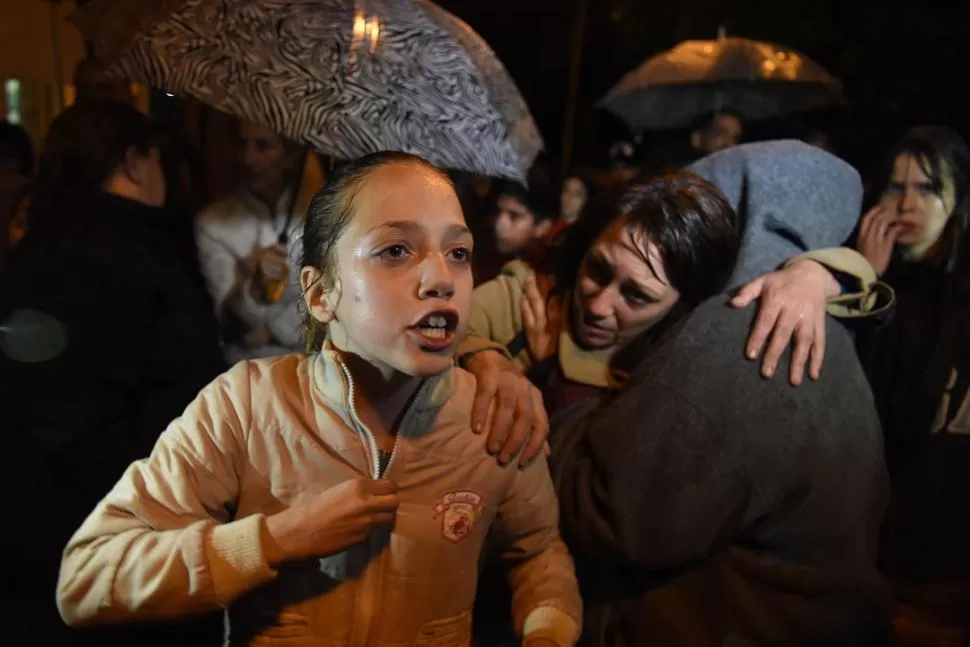 IMPOTENCIA. Sara, hermana de Valentín, expresa su bronca entre la multitud; mientras que su madre, Soledad Contreras, recibe el abrazo de un allegado. la gaceta / foto de diego aráoz