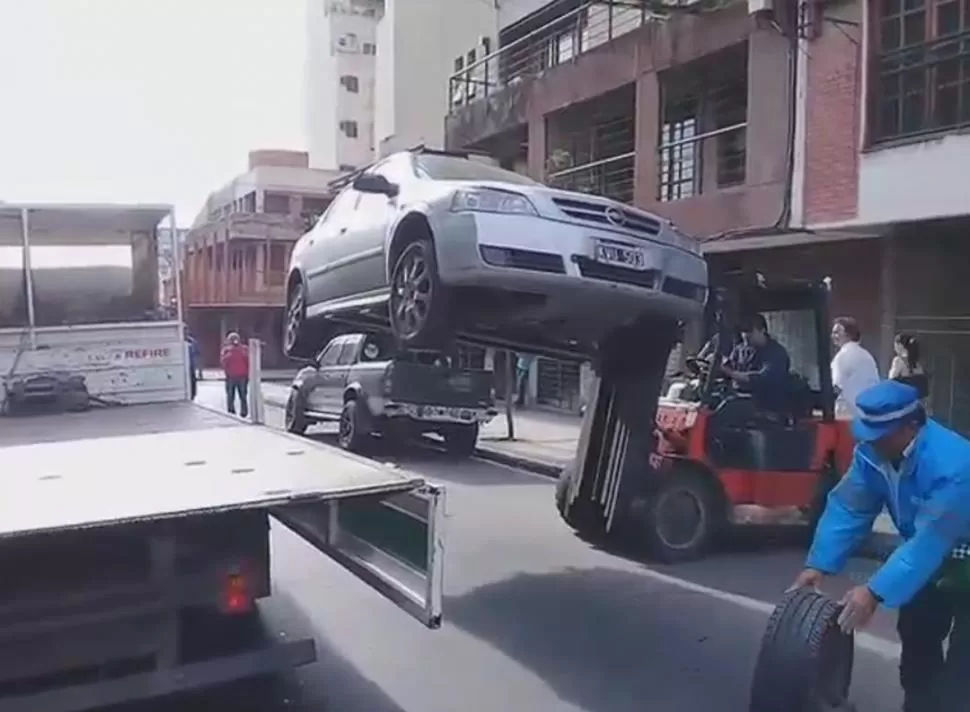 EN LO ALTO. El montacargas deposita en el camión municipal un auto que estaba mal estacionado.-