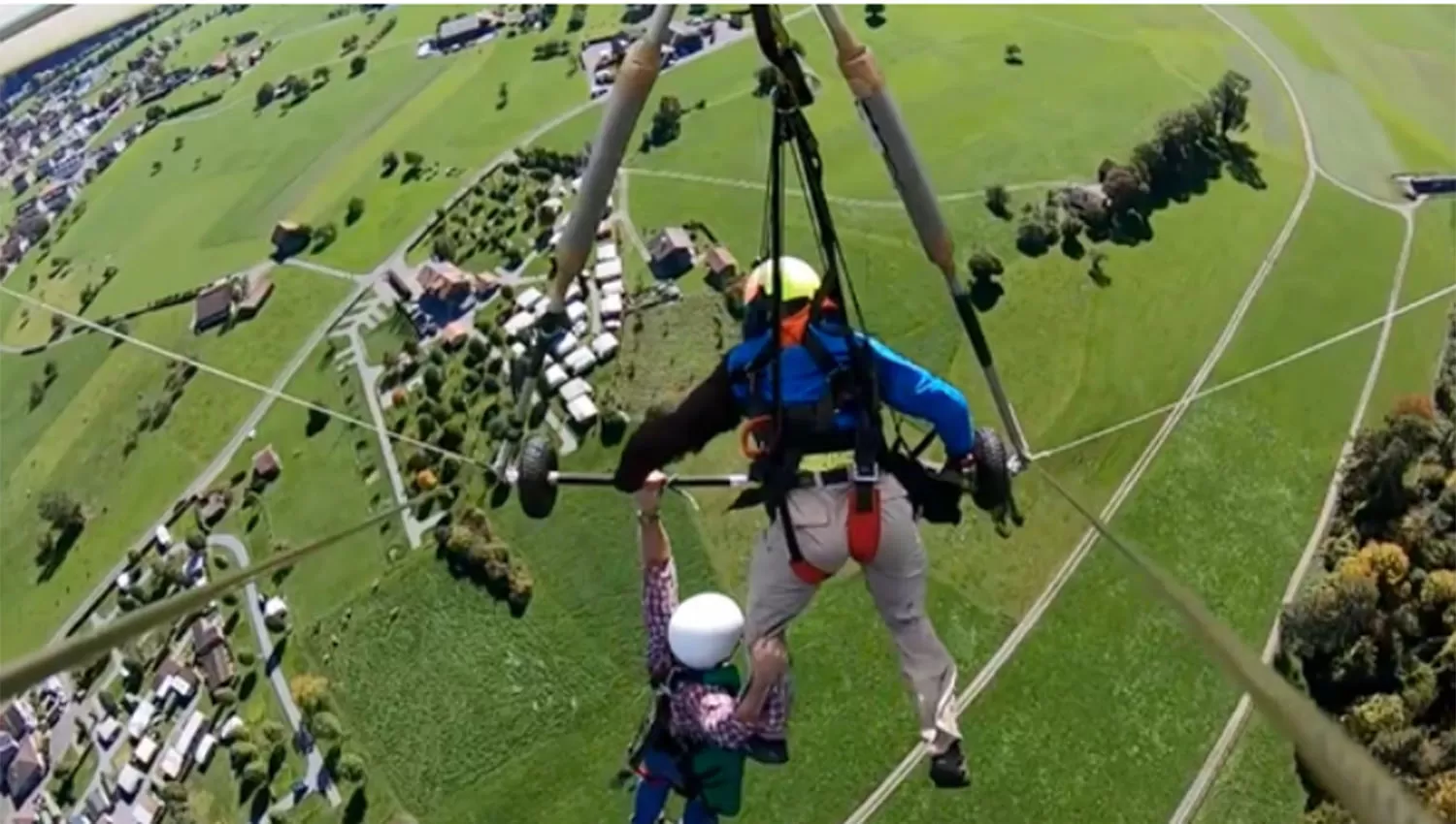 Gurksy agarrado al aparato con una sola mano y con la otra al pantalón del piloto.