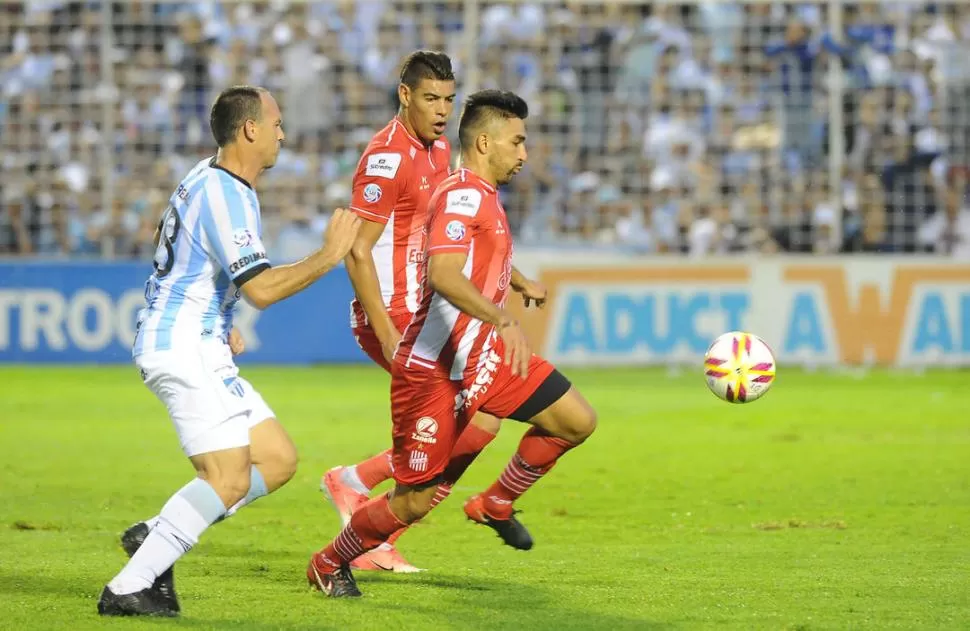 POBRE TAREA. Maximiliano Martínez lleva la pelota y es perseguido por Mauro Matos. El lateral izquierdo no tuvo un buen partido mientras que el centro delantero trató de pivotear como siempre.  LA GACETA / FOTO DE hector peralta