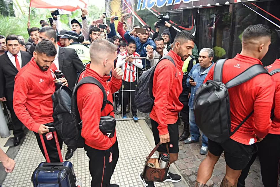 CAMINO AL TRIUNFO. Marcos Figueroa, Emiliano Purita, Matías García y Rodrigo Moreira hacen fila para subir al ómnibus. Los hinchas alentaban cantando: “esta tarde, cueste lo que cueste, tenemos que ganar”. la gaceta / fotos de josé nuno