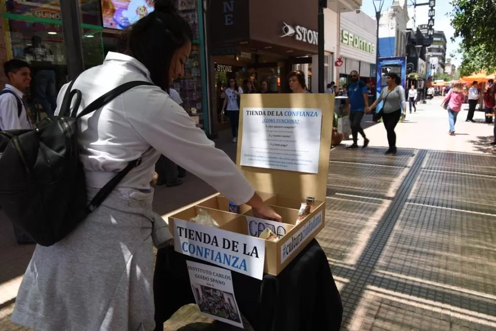 INICIATIVA EN LA CALLE. Estudiantes del Instituto Guido Spano instalaron su “Tienda de la confianza” en la esquina de Muñecas y Mendoza. LA GACETA / FOTO DE JOSÉ NUNO.-