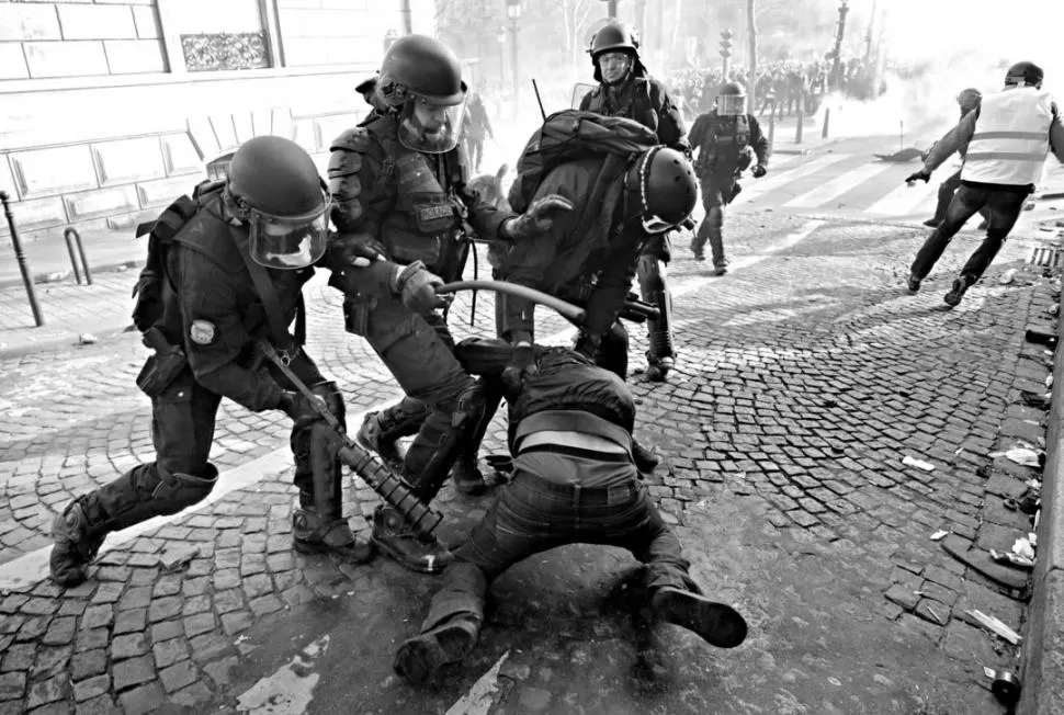 POR LA FUERZA. Los efectivos policiales controlan y detienen ayer a un manifestante durante la protesta.  REUTERS 