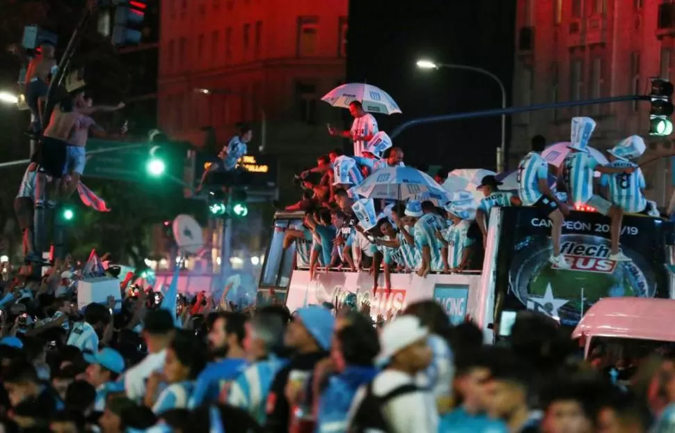 FESTEJO CON LA GENTE. El plantel de Racing celebra subido a un colectivo descapotable, entre sus hinchas. reuters