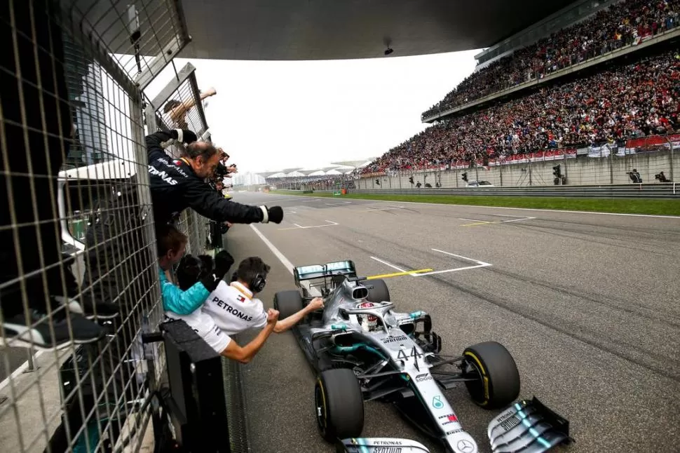 LLEGADA TRIUNFAL. Lewis Hamilton ya cruzó la meta y recibe el saludo de sus mecánicos, ante la vista de una multitud en el circuito de Shanghai. PRENSA MERCEDES