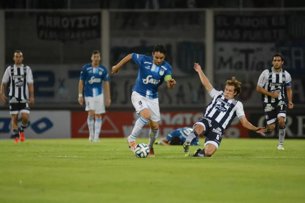 AYER Y HOY. Diego Barrado, ex Atlético, lleva la pelota ante la marca de Nery Leyes, allí en Talleres, hoy en el “Decano”. Al fondo, Sbuttoni (parado) y Longo (en el piso). Fue en 2013, en el último triunfo en Córdoba. la gaceta / archivo