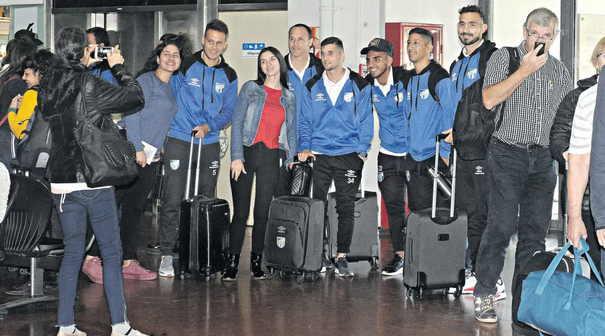 CON TODA LA ILUSIÓN. Fanáticas decanas se fotografiaron con jugadores de Atlético en el aeropuerto ayer, antes de partir a Buenos Aires. LA GACETA/FOTO DE ANTONIO FERRONI