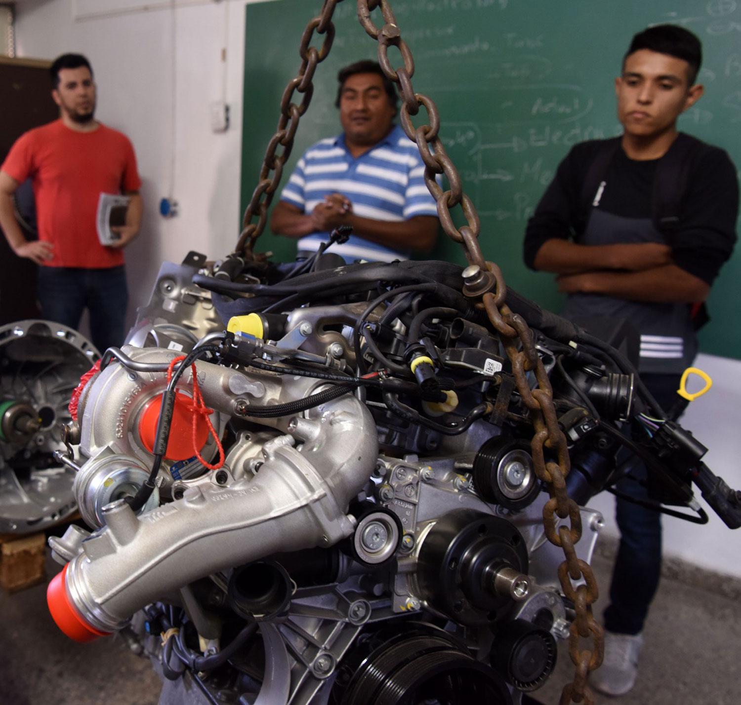 LA JOYA. Mauro, el primero a la derecha de la imagen, mira el motor Mercedes Benz donado a la escuela.