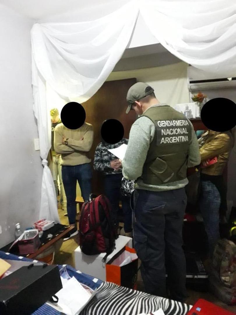 PROCEDIMIENTO. Un gendarme registra el lugar, frente a varias personas.  