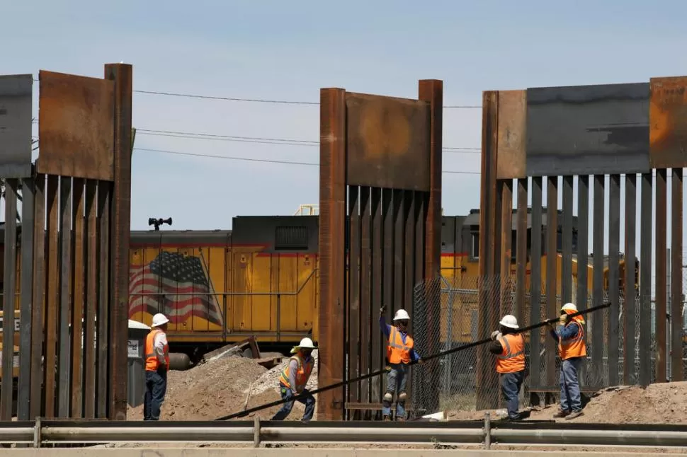 MURO. Obreros trabajan en esta drástica delimitación de la frontera. Reuters (archivo)