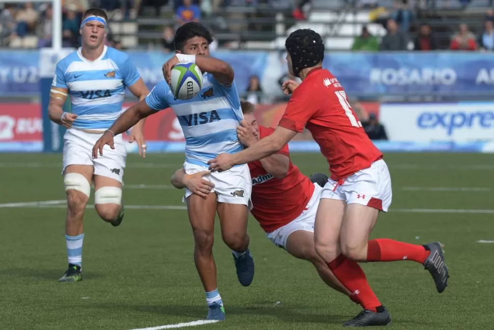 BUSCANDO EL OFFLOAD. El tucuman Gonzalo García intenta soltar el pase ante la doble marca. El medio scrum de Natación jugó un buen partido. TÉLAM