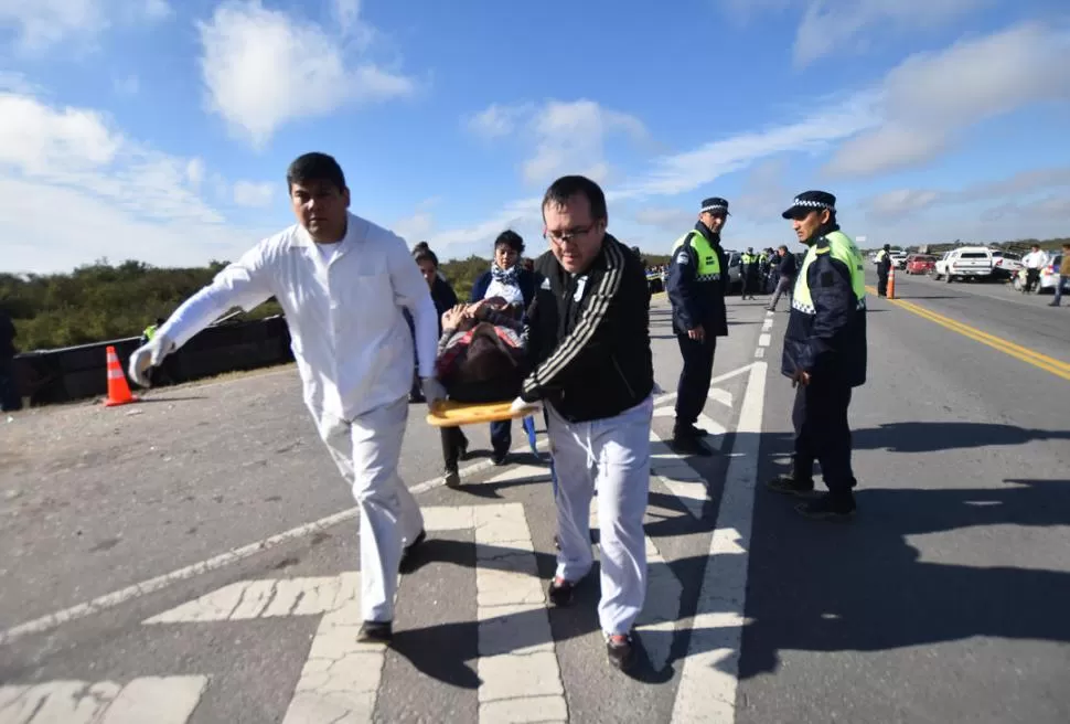 GRUPOS DE EMERGENCIAS. Personal del Siprosa traslada al Hospital de La Madrid a uno de los accidentados, desde el cruce de las rutas 308 y 157.  la gaceta / foto de osvaldo riopoll