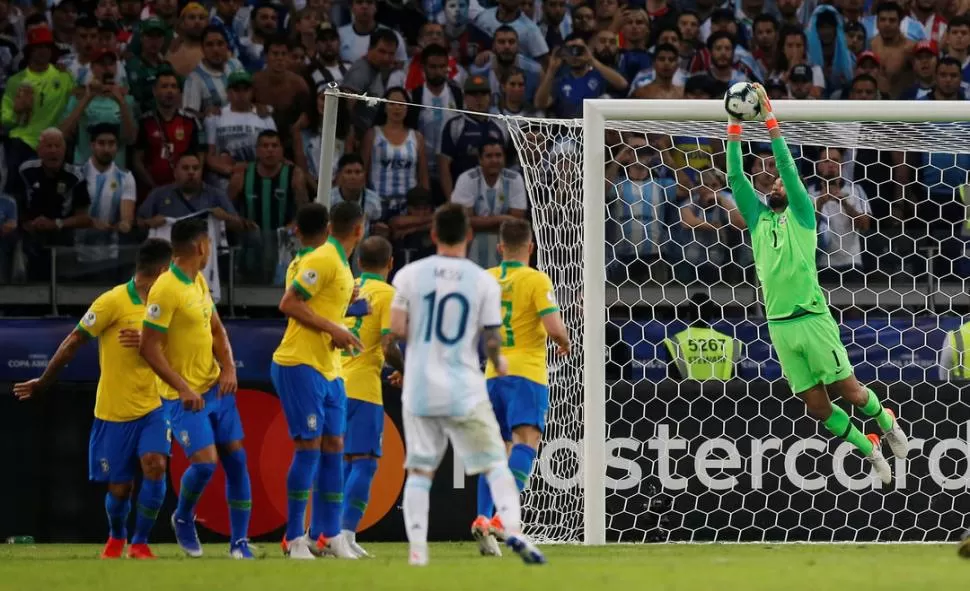 NI ESA. Messi acaba de patear otro de sus tiros libres y Alisson, otro villano que tuvo que enfrentar Argentina, la descuelga con facilidad. Brasil, tras cinco partidos, sigue sin recibir un gol en el torneo. reuters