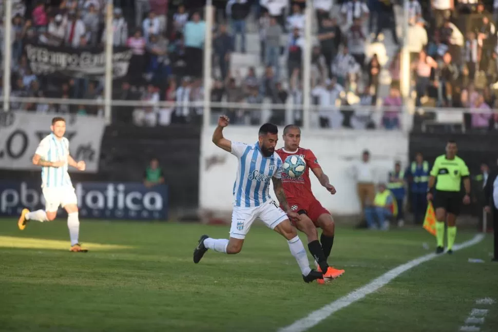 CUERPO A CUERPO. Ariel Rojas intenta ganar la posesión sobre la banda. Atlético apostó por un medio campo bien poblado en Santiago, pero no logró imponerse frente a un rival que lo sorprendió de entrada. la gaceta / foto de diego aráoz (enviado especial)