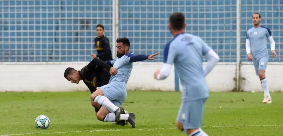 GRAN ESFUERZO. El volante Ariel Rojas busca hacerse de la pelota ante el asedio de un jugador del equipo santiagueño. El partido entre los titulares se extendió a dos tiempos de 40 minutos. 