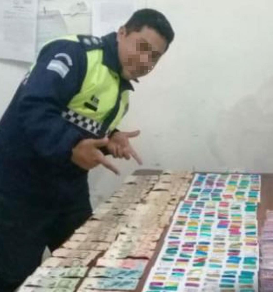 La foto de la polémica. El policía posa junto al secuestro de droga y dinero.