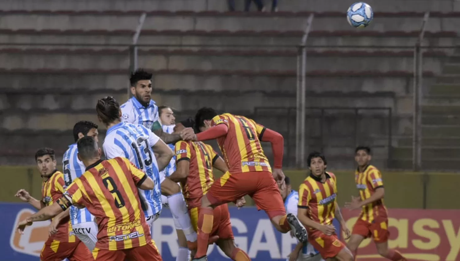 LA PELOTA NO TIENE DUEÑO. Javier Toledo se eleva más alto que todos, entre los delanteros del conjunto correntino. 