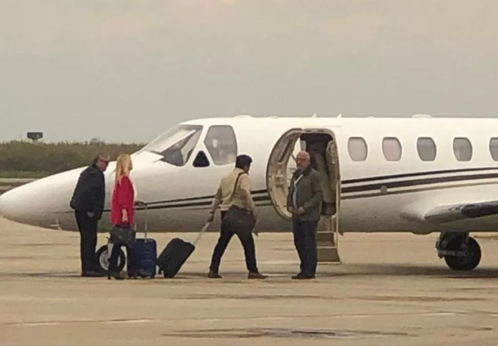 LA IMAGEN QUE CALENTÓ LAS REDES. Magario (de rosa) y Espinoza con valijas, junto al avión oficial de la Provincia.