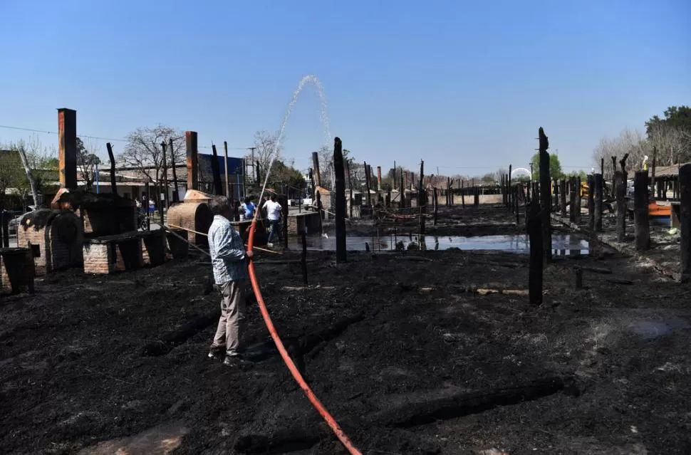 IMAGEN DESOLADORA. Un hombre arroja agua sobre los restos de los ranchos que fueron alcanzados y destruidos rápidamente por las llamas. la gaceta / foto de Osvaldo Ripoll