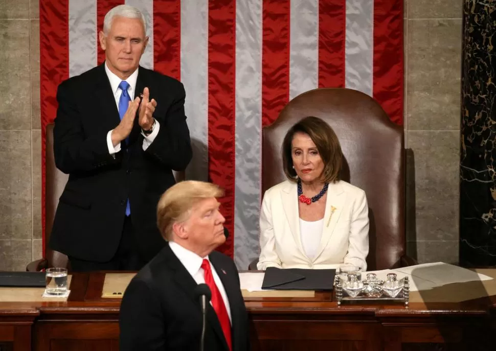 GESTOS. El vicepresidente Mike Pence aplaude a Trump en la Cámara de Representantes. La demócrata Nancy Pelosi, en cambio, ni siquiera lo mira. REUTERS