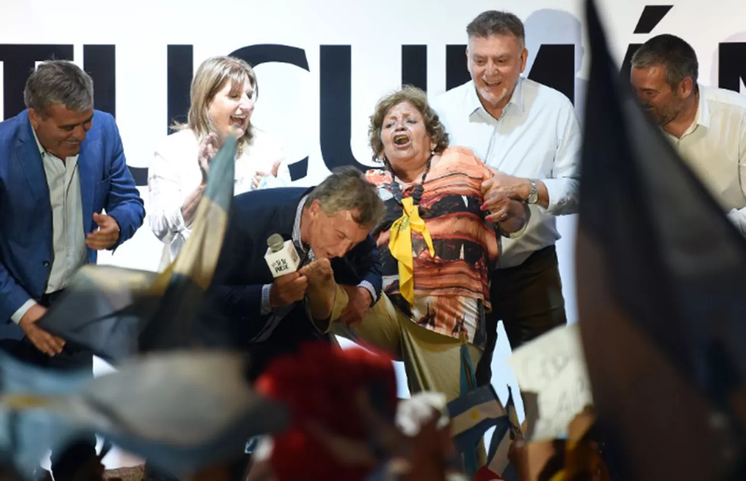 El momento en el que Macri le besó el pie descalzo a Manuela, que perdió el zapato cuando la subieron al escenario.