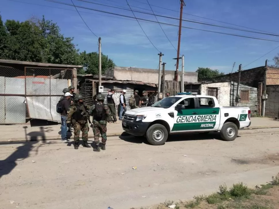 MOVIMIENTO. Agentes de la fuerza de seguridad federal inspeccionan una de la treintena de viviendas identificadas en el operativo. 