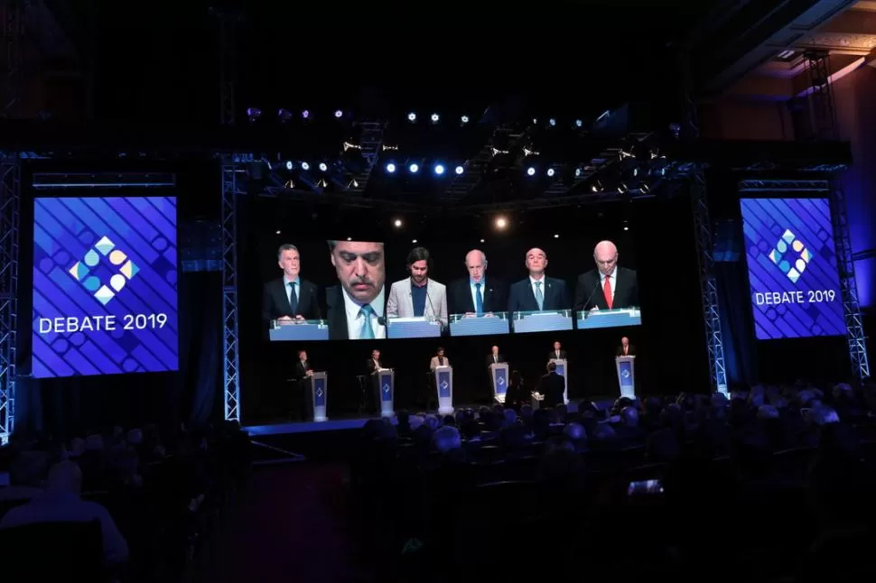 GESTOS EN LA PANTALLA GIGANTE. Macri, Fernández -que estaba en uso de la palabra-, Del Caño, Lavagna, Gómez Centurión y Espert, en un momento del segundo y último debate entre los seis candidatos a presidente de la Nación. 