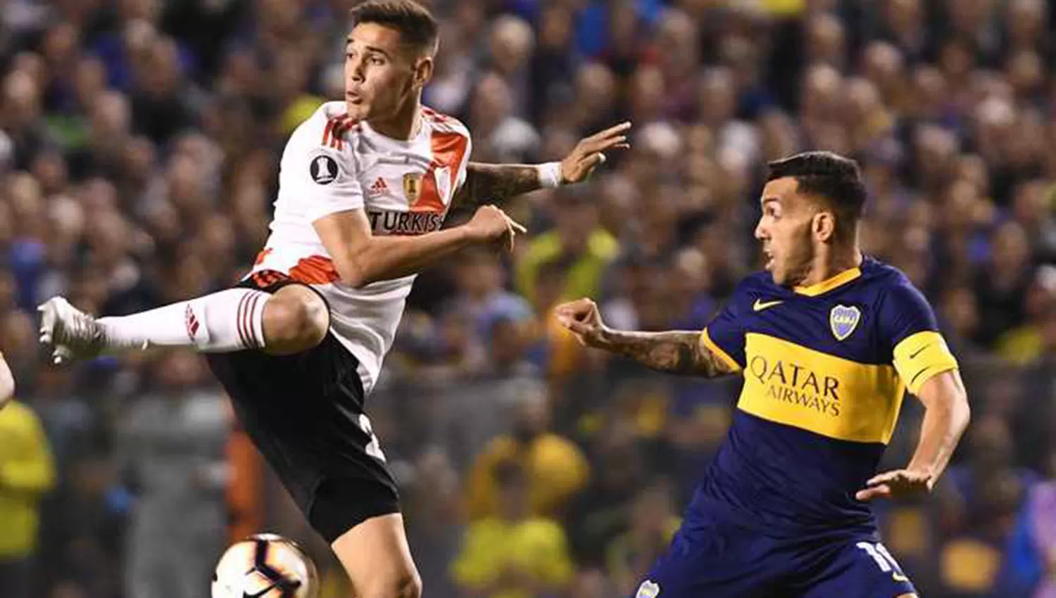 Martínez Quarta y Tevez pugnan por la pelota. Primó la lucha sobre el juego en la parte inicial. (TÉLAM)